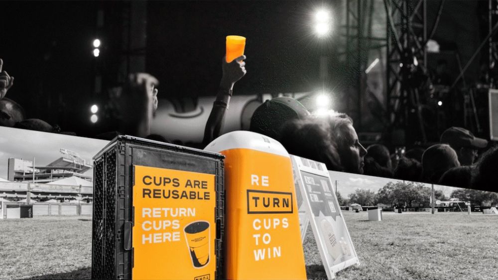 TURN cup return station at a festival, with a reusable cup raised in the crowd